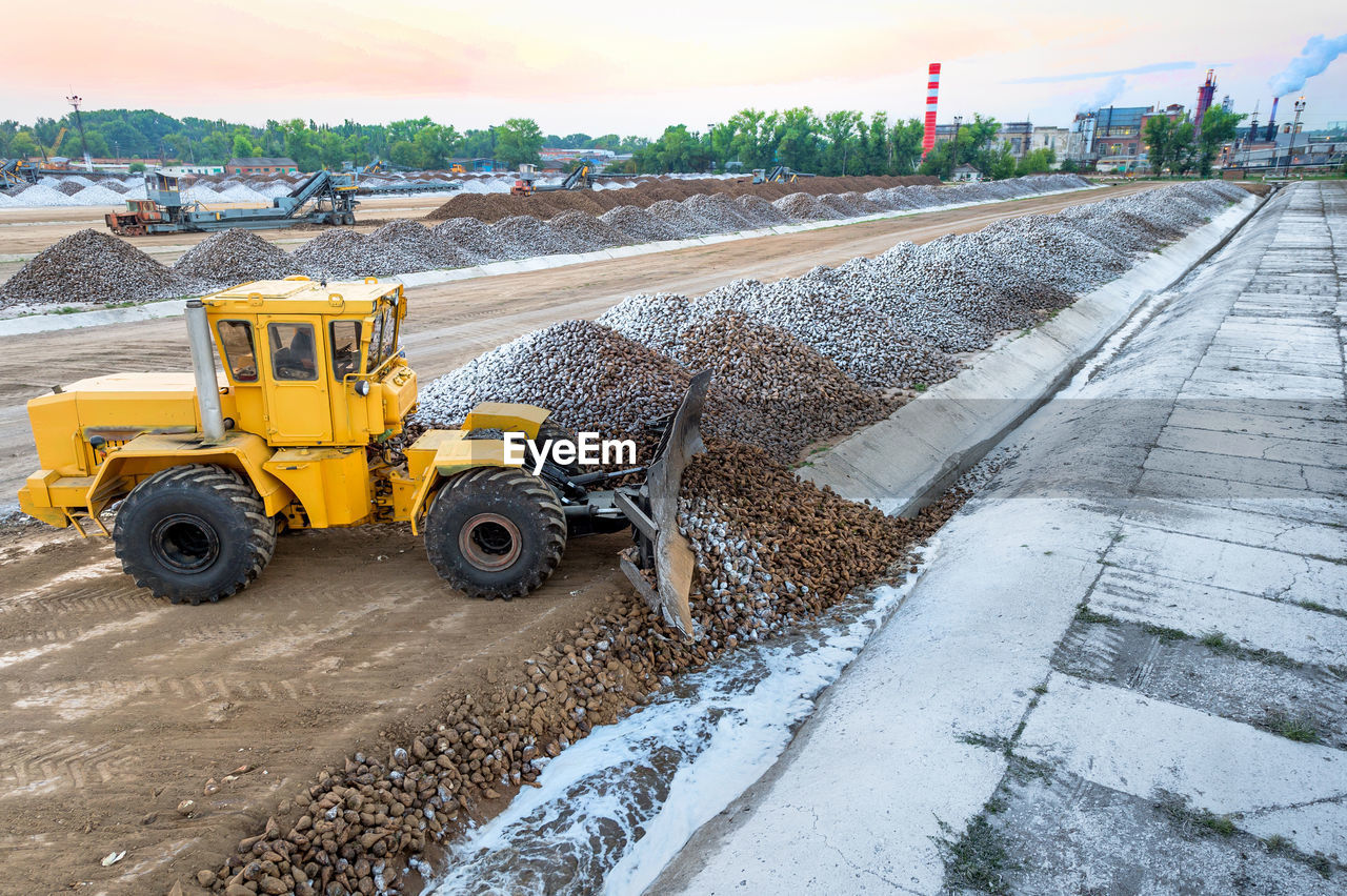 Earth mover at construction site against sky