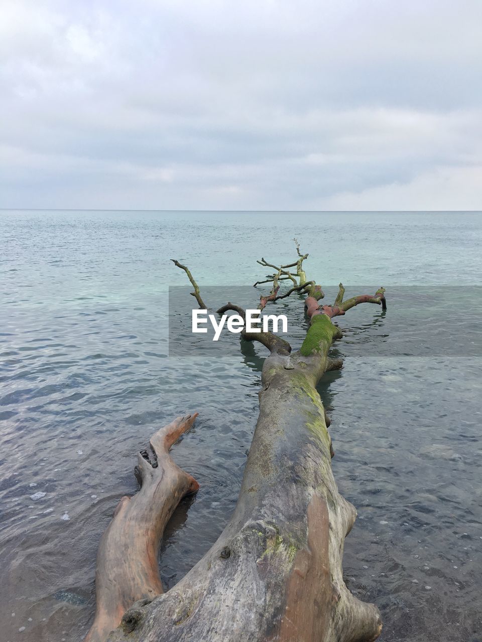 Scenic shot of calm sea against cloudy sky