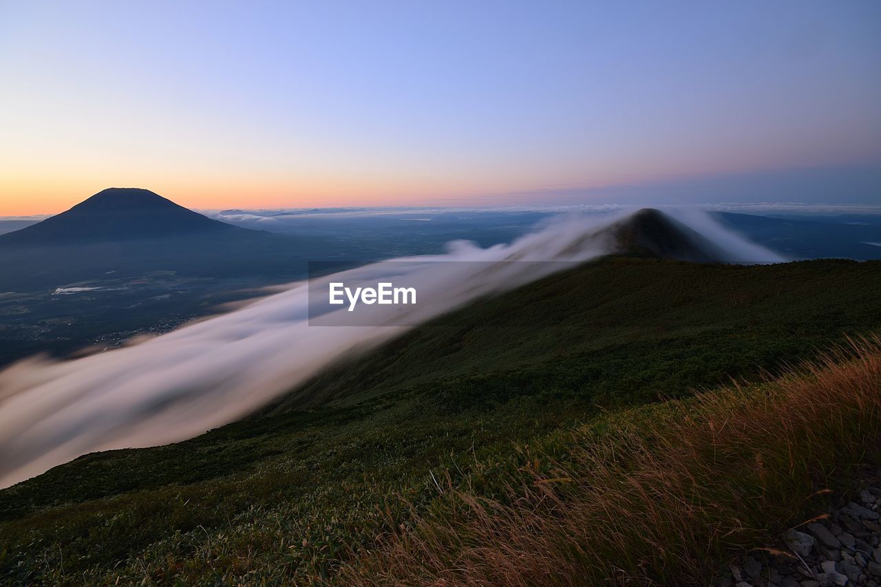 Scenic view of land against sky during sunset