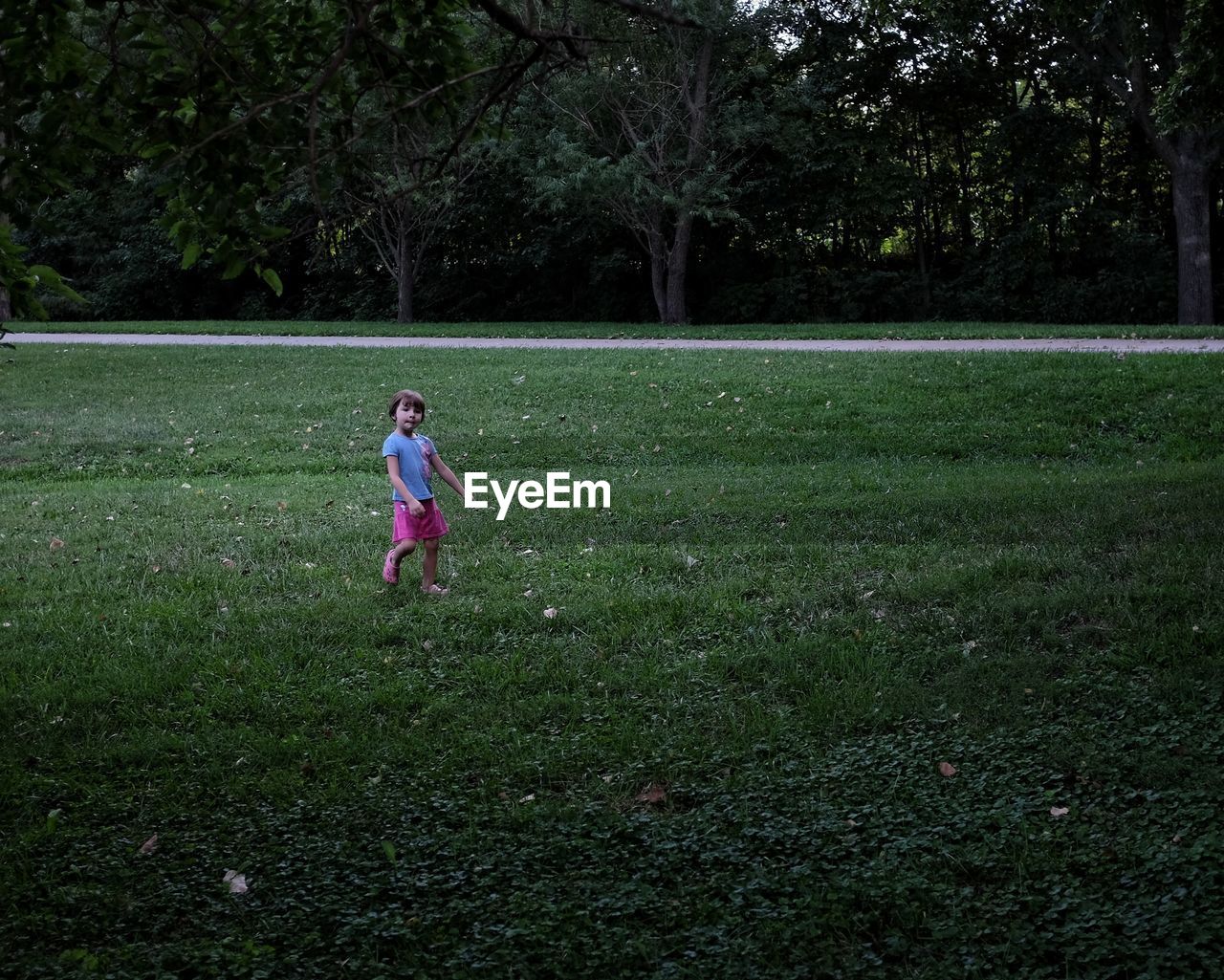 Girl playing on grassy field at park