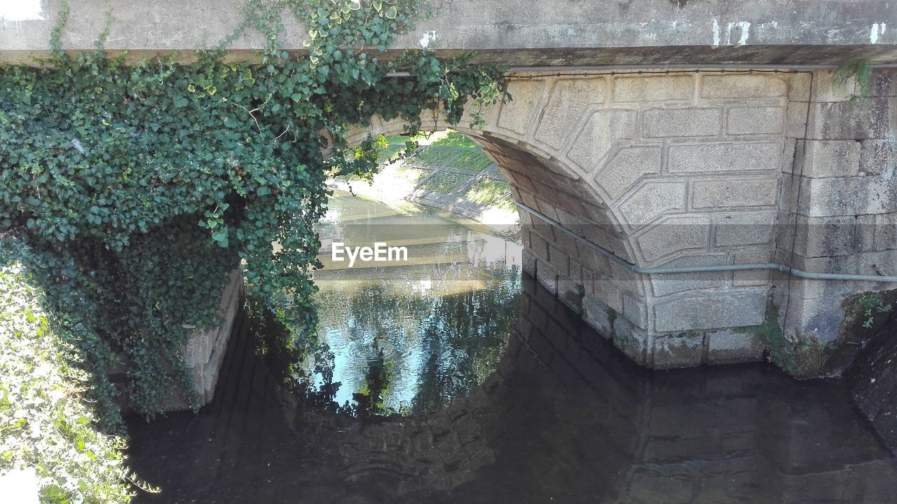 View of canal going under a stone bridge