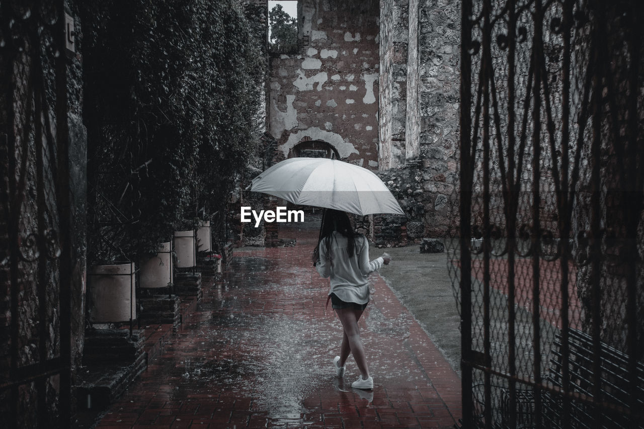 Woman walking on wet umbrella during monsoon