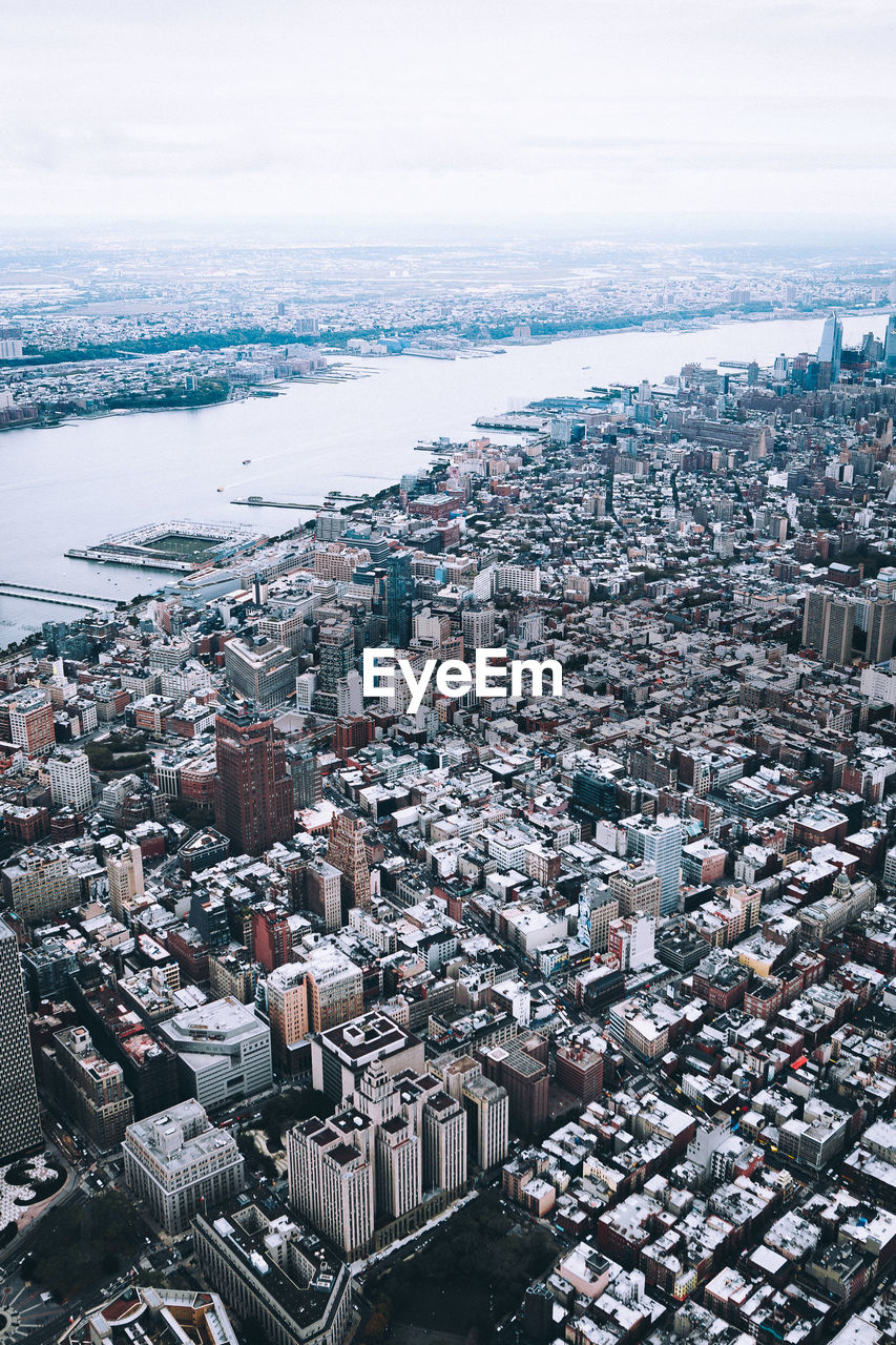 High angle view of cityscape by sea against sky