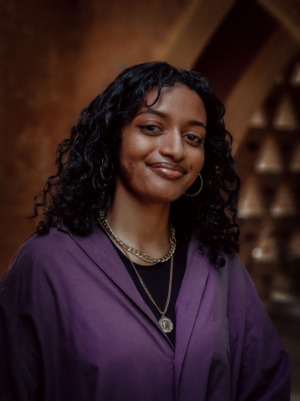 PORTRAIT OF A SMILING YOUNG WOMAN WITH PURPLE