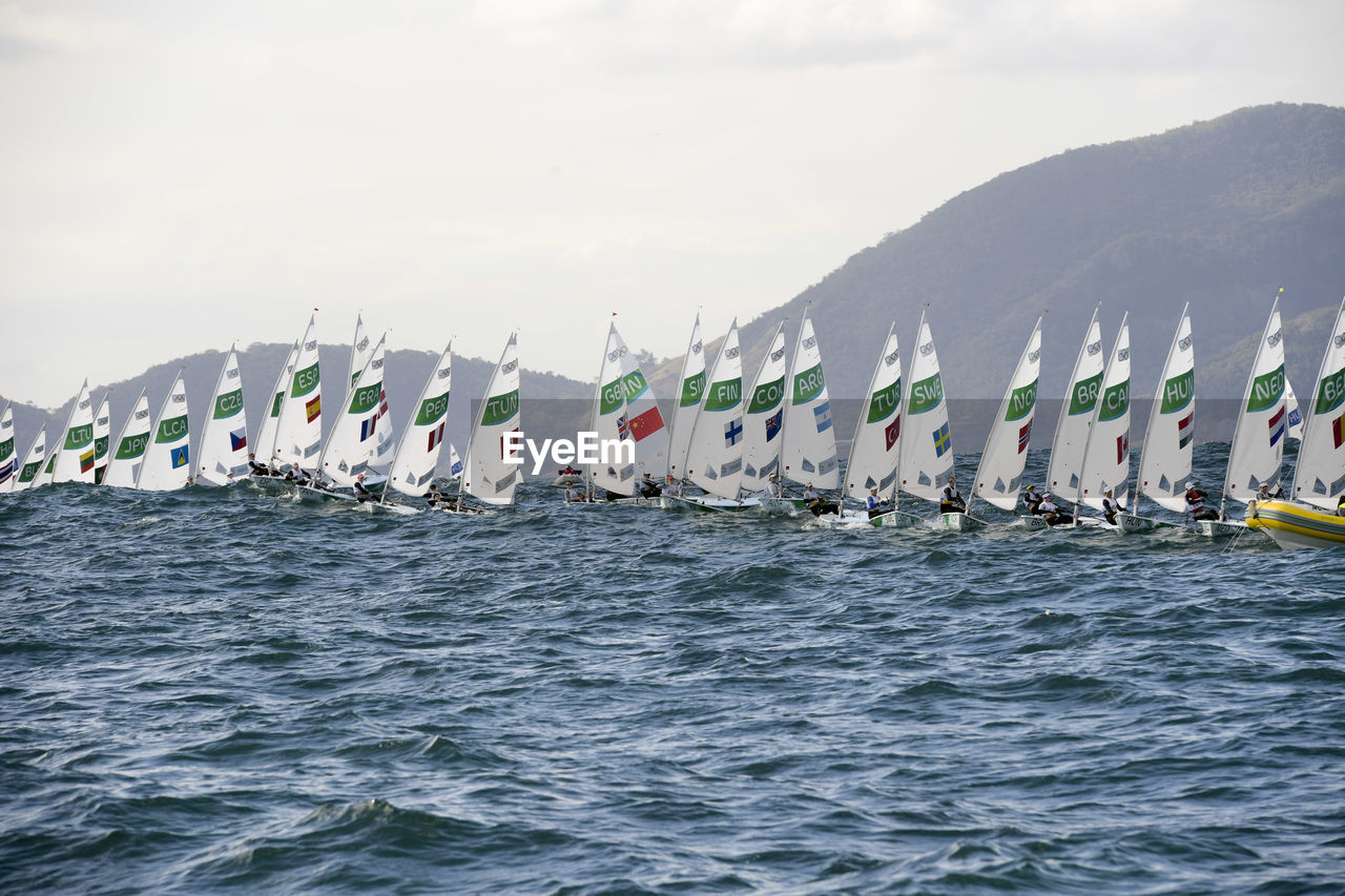 Sailboats sailing in sea against sky