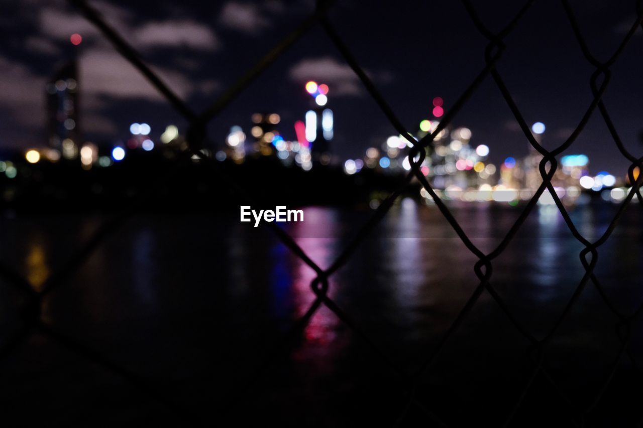 DEFOCUSED IMAGE OF ILLUMINATED LIGHTS AT NIGHT