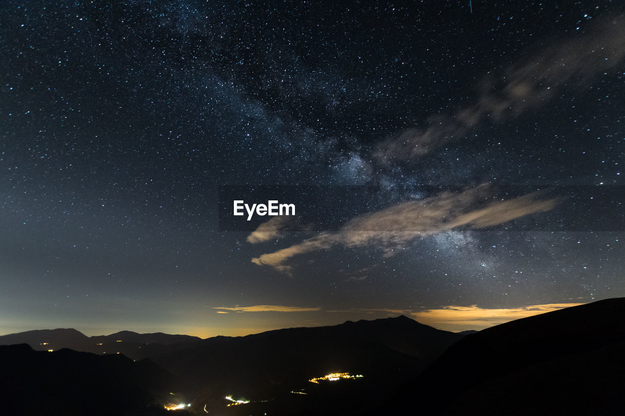 SCENIC VIEW OF SILHOUETTE MOUNTAINS AGAINST STAR FIELD