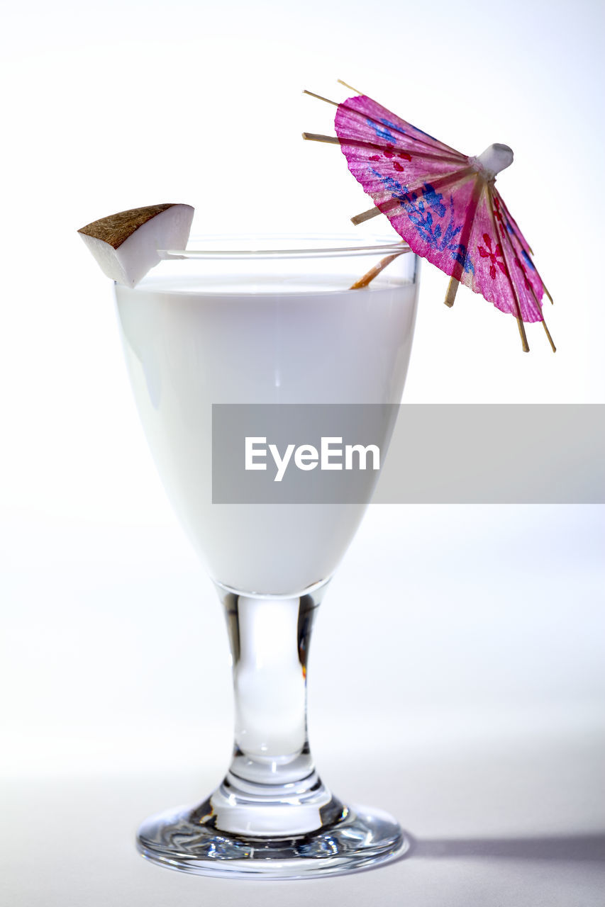 Coconut milk in a glass with a coktail unbrella