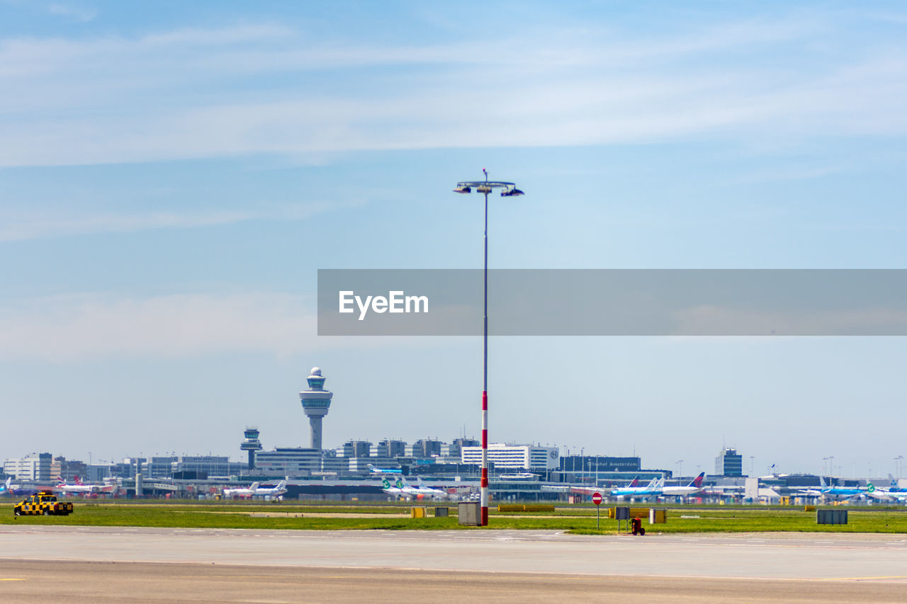 Floodlight at amsterdam schiphol airport against sky on sunny day