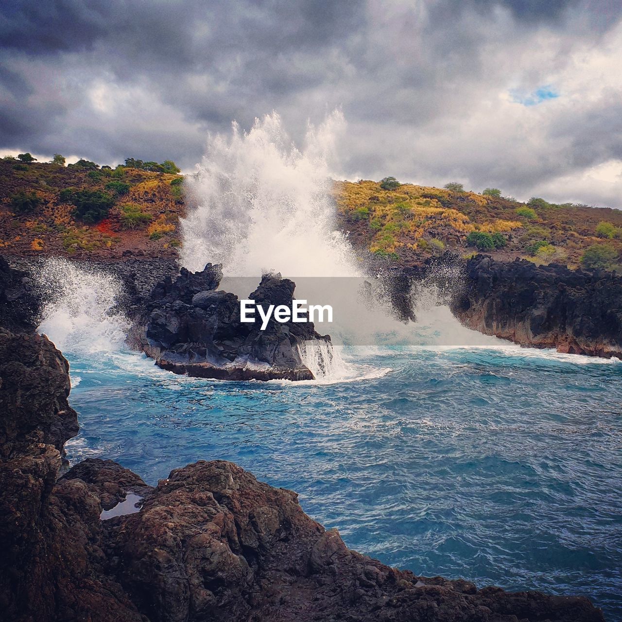 SCENIC VIEW OF SEA WAVES SPLASHING ON ROCKS