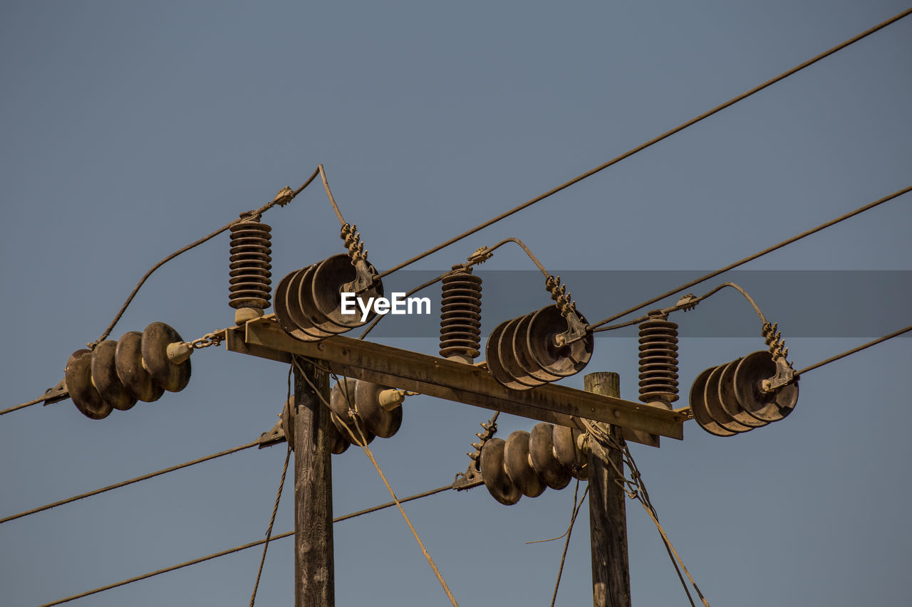 Low angle view of electricity pylon against sky