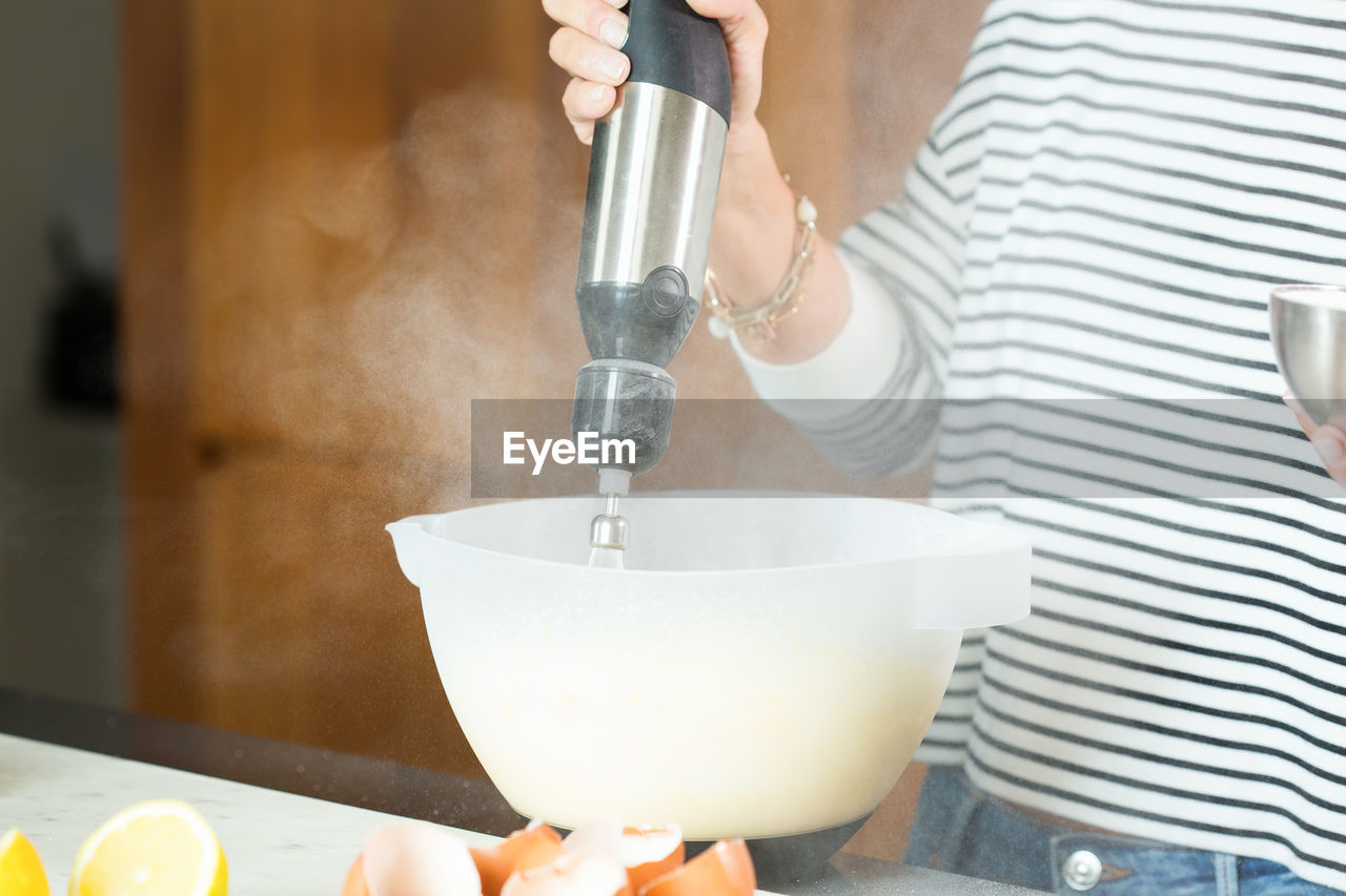 Woman kneading the dough while cooking apple pie in the modern kitchen