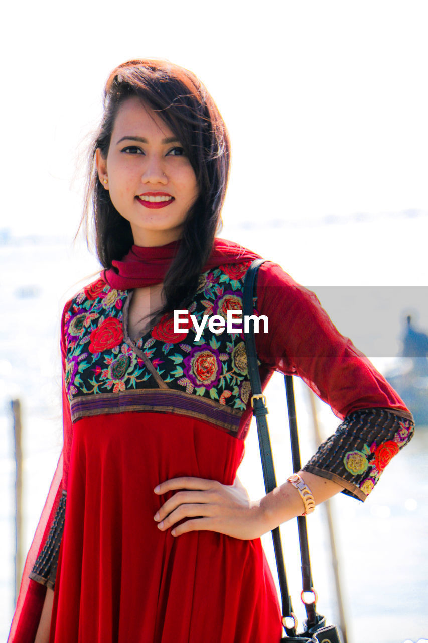 Portrait of young woman standing at beach