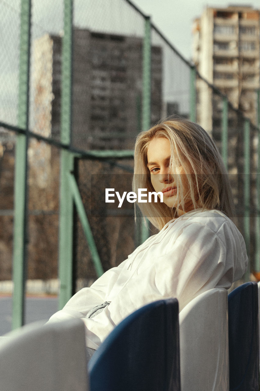 Woman looking away while sitting outdoors