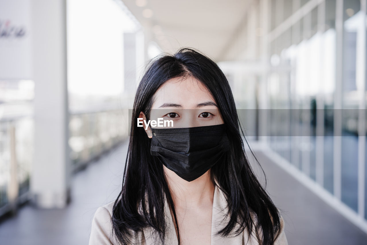 Close up of young business woman wearing face mask in city. corona virus concept