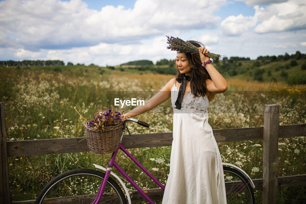 Asian woman with retro bike in flower field