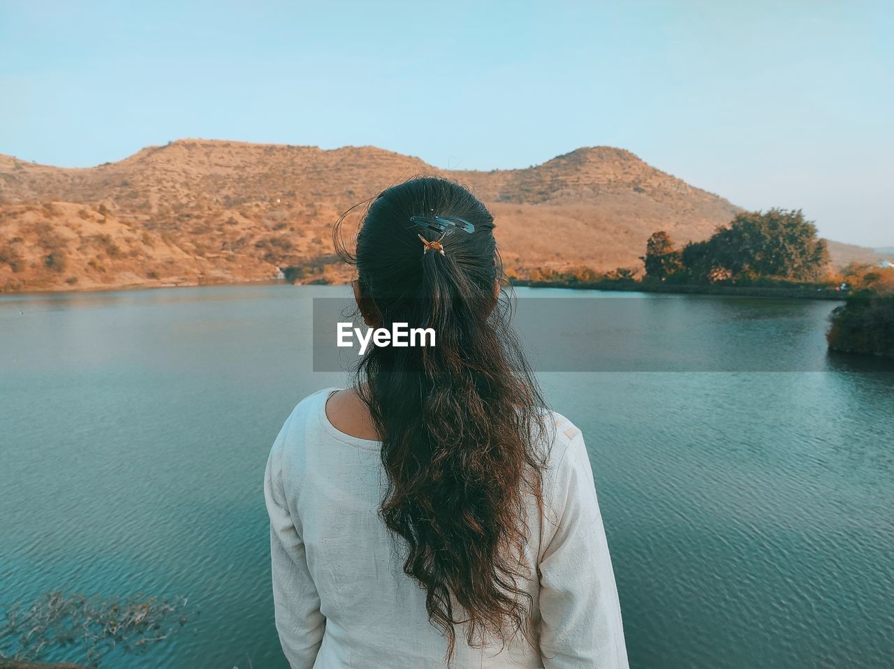 Rear view of woman looking at mountains against sky