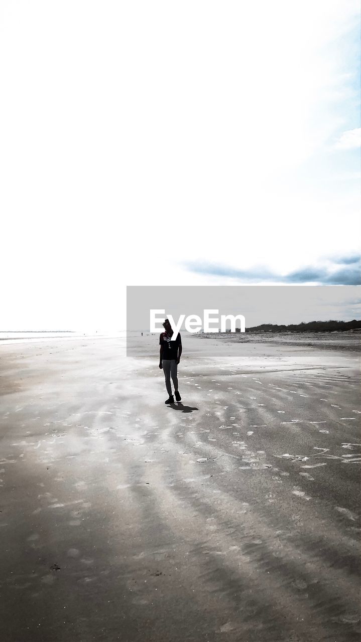 FULL LENGTH REAR VIEW OF MAN STANDING ON BEACH