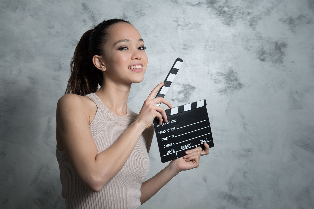 Close-up portrait of woman holding film slate