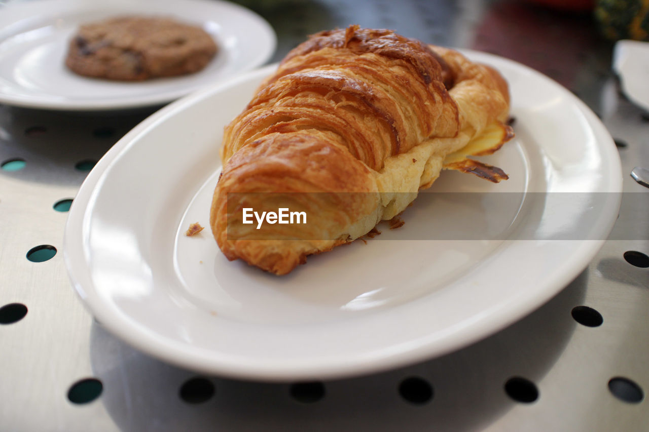 Close-up view of fresh croissant on white plate