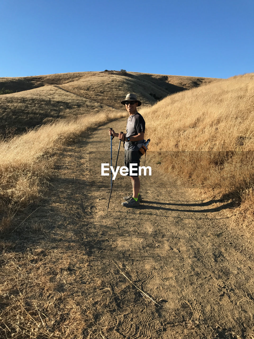 Side view of man standing on mountain against clear sky