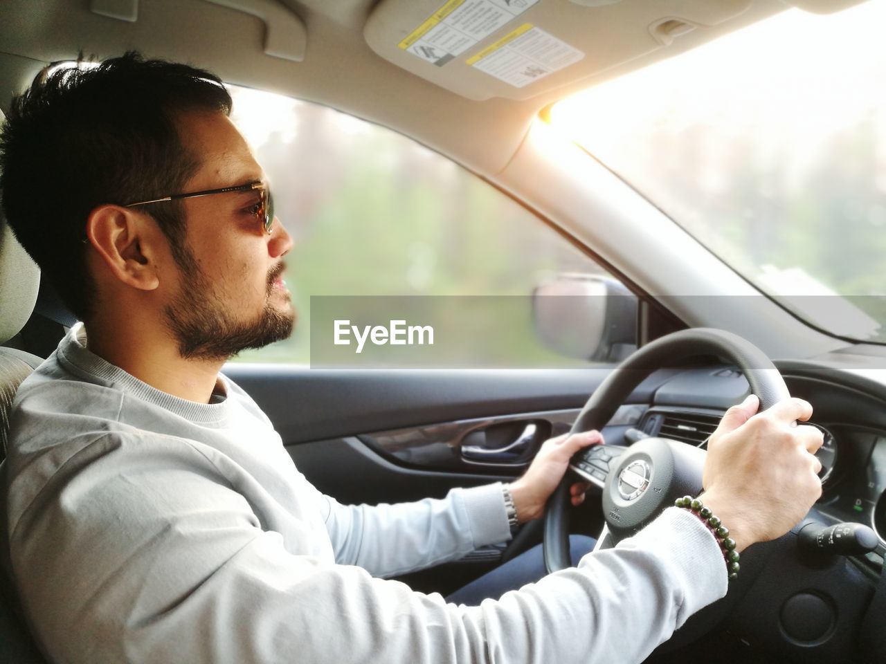 Young man wearing sunglasses sitting in car