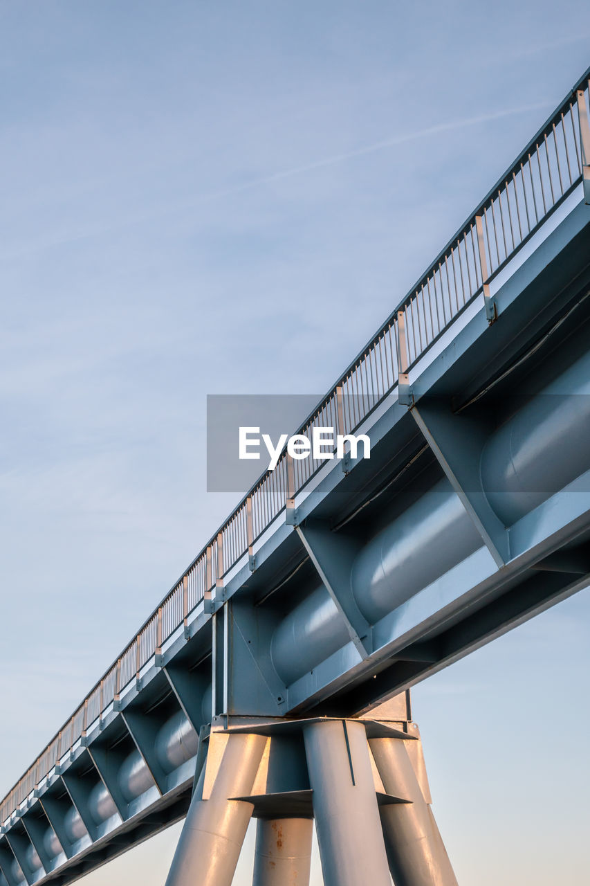 LOW ANGLE VIEW OF METALLIC BRIDGE AGAINST SKY DURING SUNSET