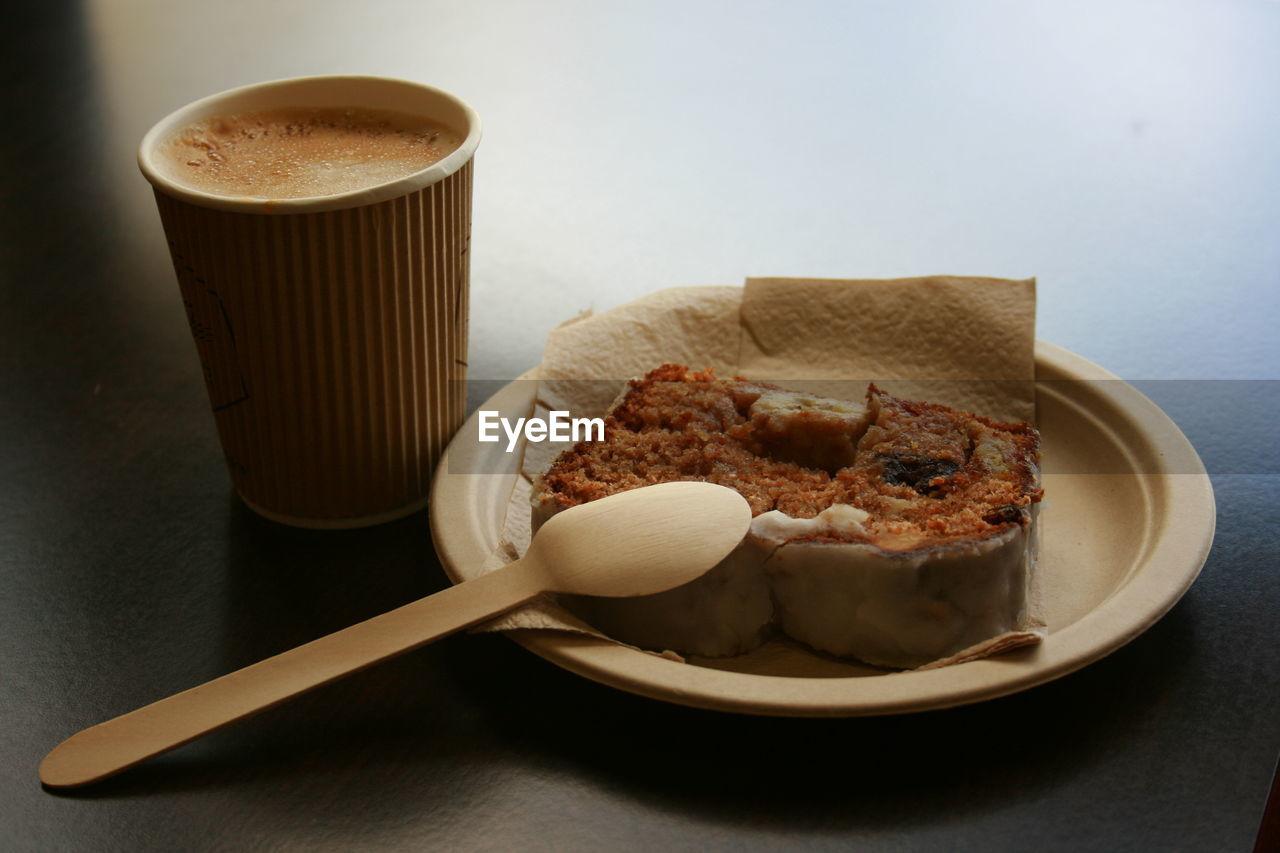 CLOSE-UP OF CUP OF COFFEE AND BREAD ON TABLE