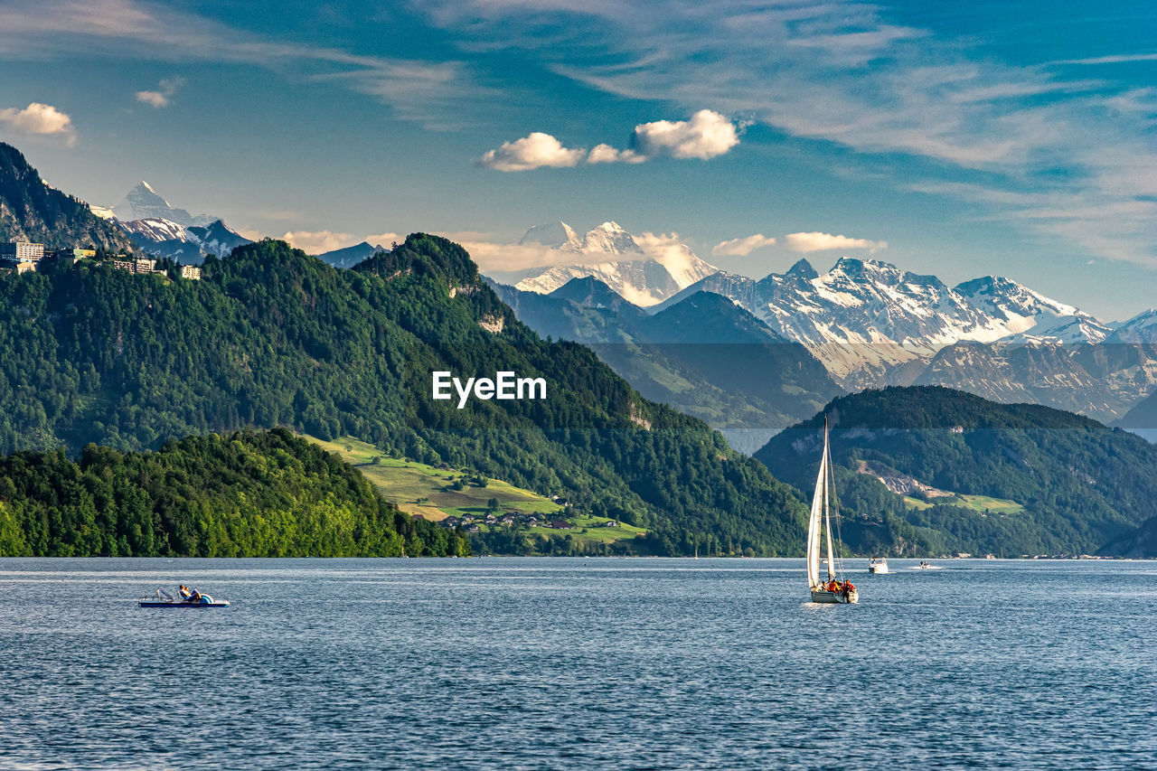 Sailboat on sea against mountains