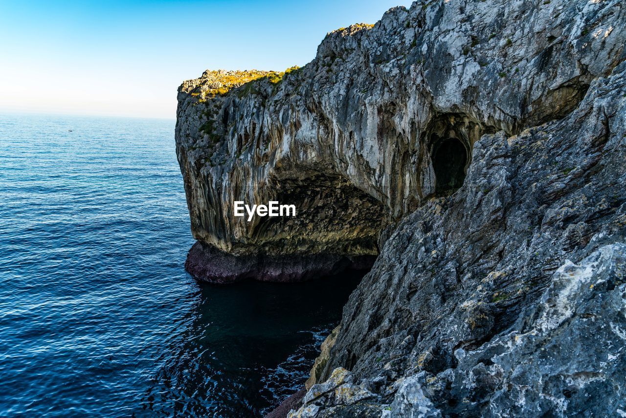 ROCK FORMATIONS IN SEA AGAINST SKY