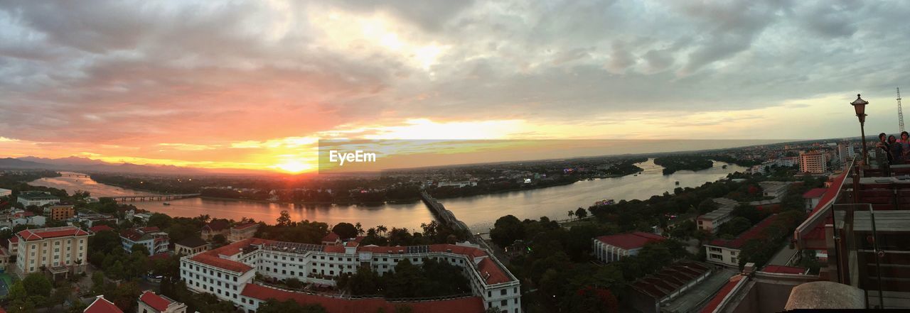 PANORAMIC VIEW OF CITYSCAPE AGAINST SKY AT SUNSET