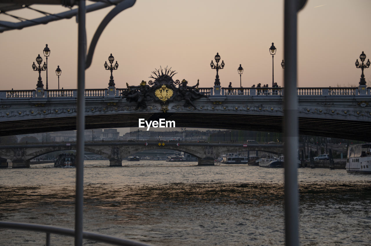 BRIDGE OVER RIVER IN CITY AGAINST CLEAR SKY