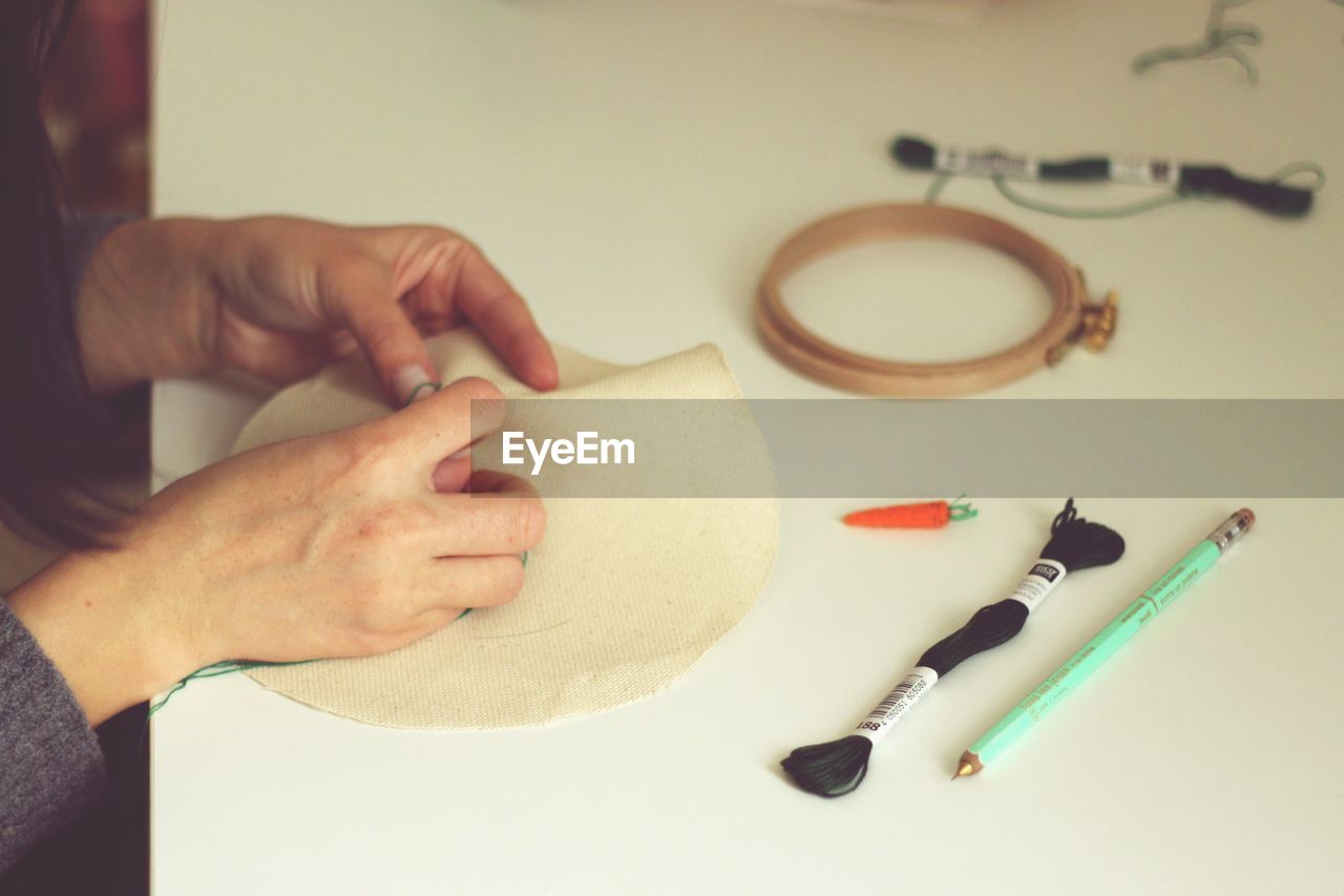Human hands embroidering cloth
