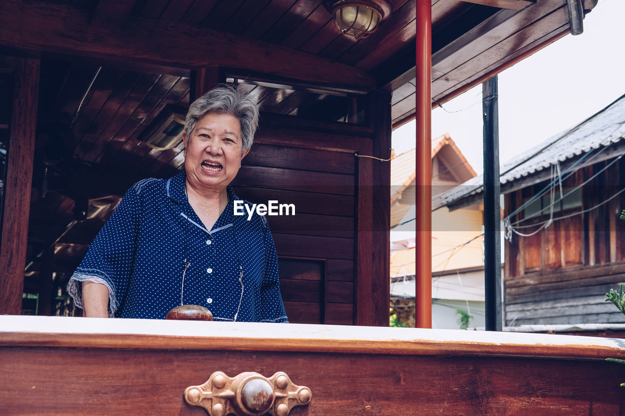 Portrait of a smiling senior woman standing tran