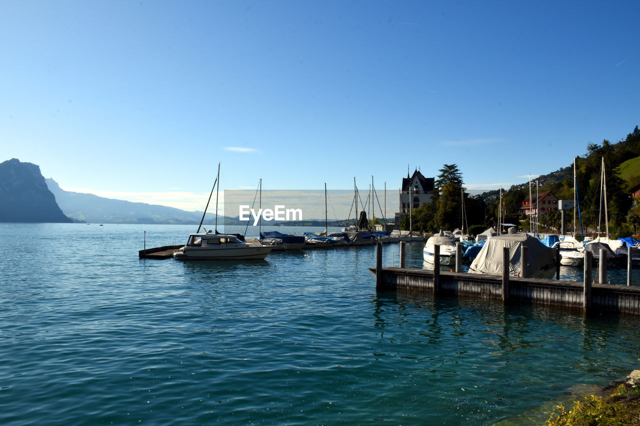 Sailing boats resting in the port of vitznau on lake lucerne with view of mountain ranges