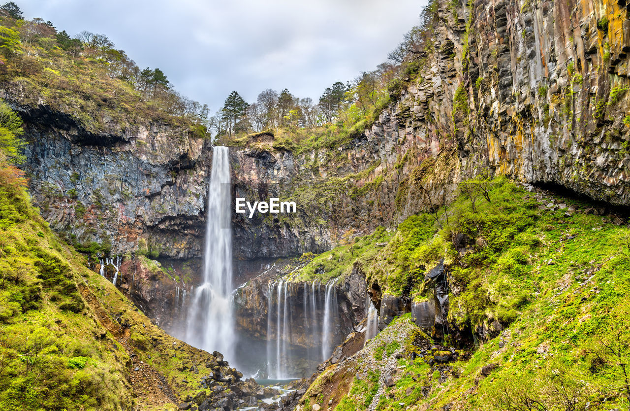 SCENIC VIEW OF WATERFALL AMIDST ROCKS