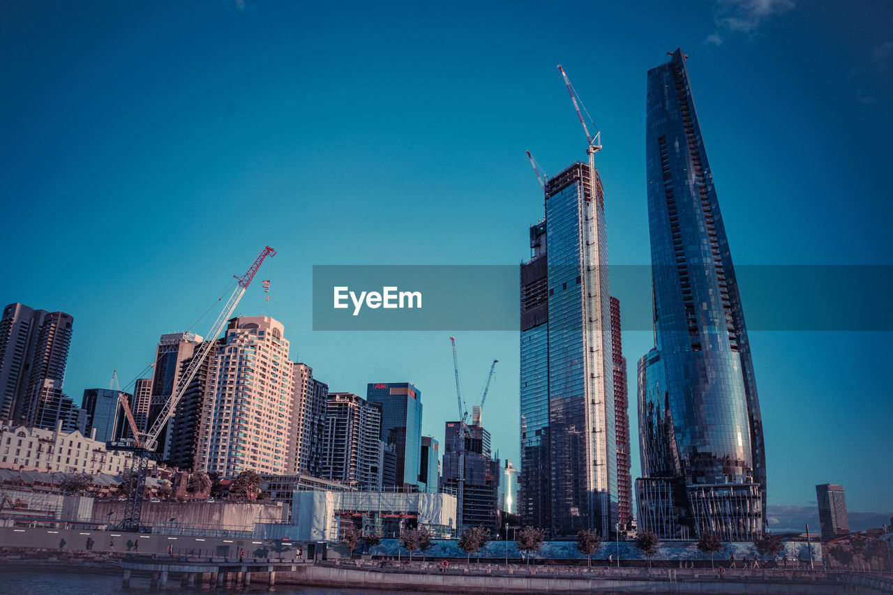 modern buildings in city against clear blue sky