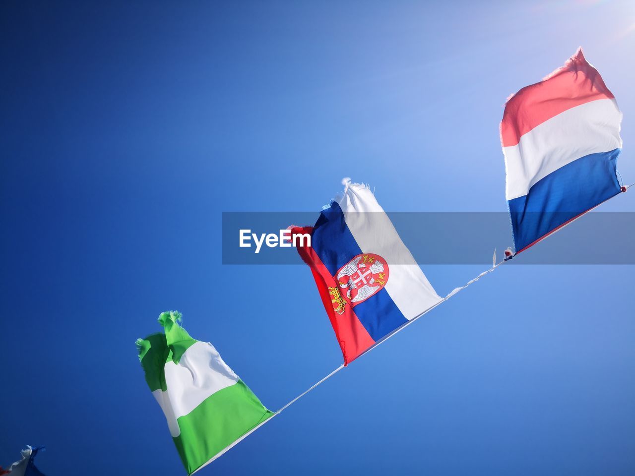 LOW ANGLE VIEW OF FLAG FLAGS AGAINST BLUE SKY