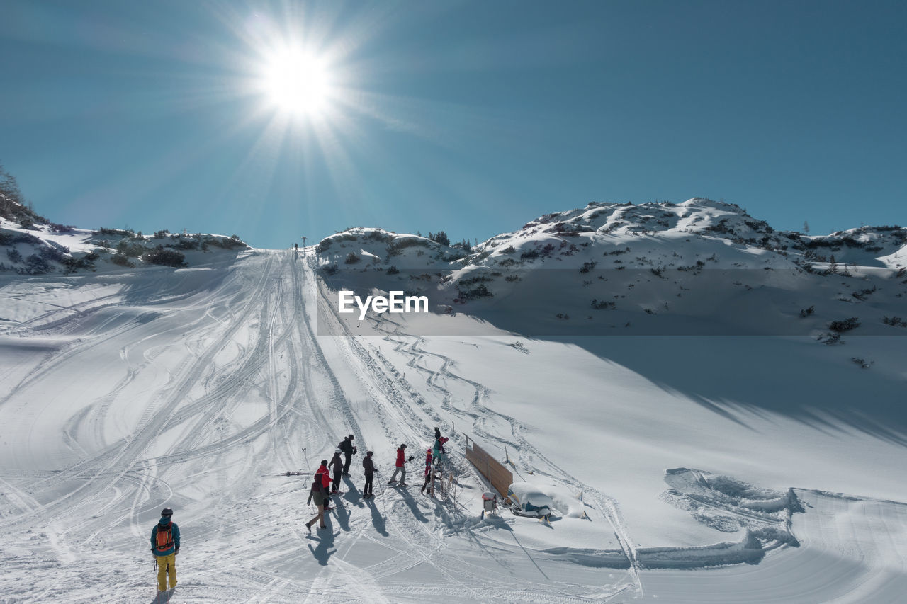 People on ski slope on sunny day