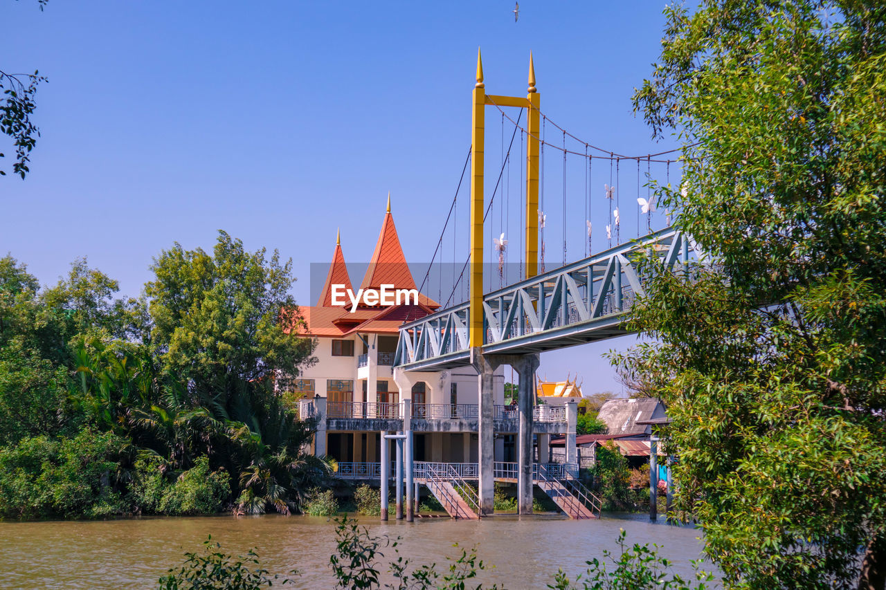 VIEW OF BRIDGE OVER RIVER BY BUILDING AGAINST SKY