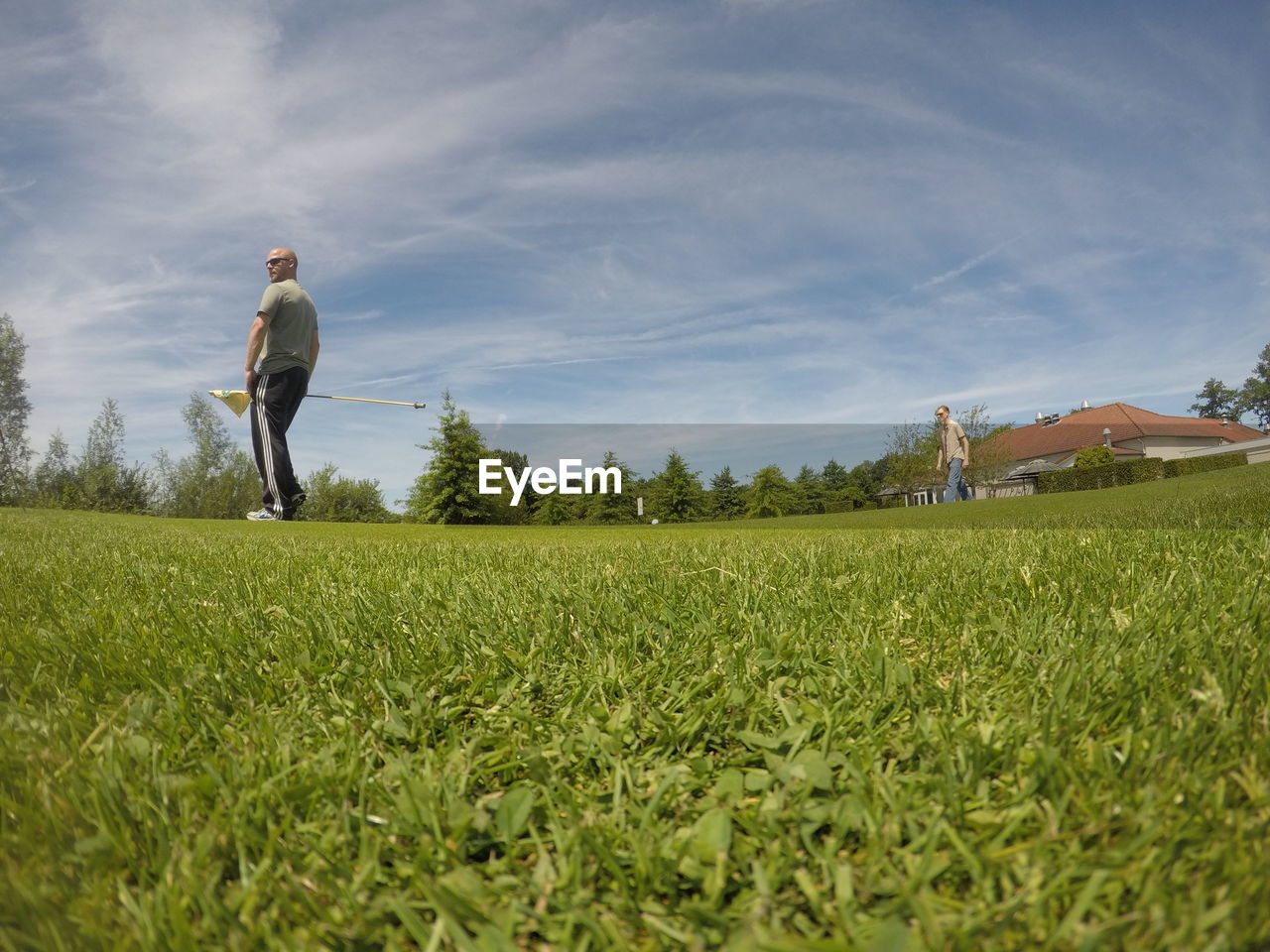 FULL LENGTH OF MAN ON GOLF COURSE AGAINST SKY