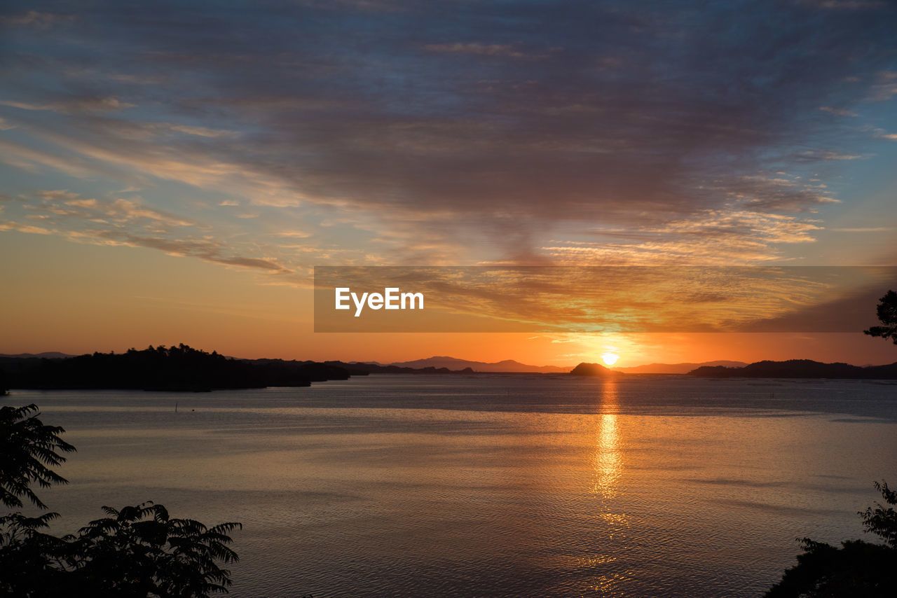 Scenic view of lake against orange sky