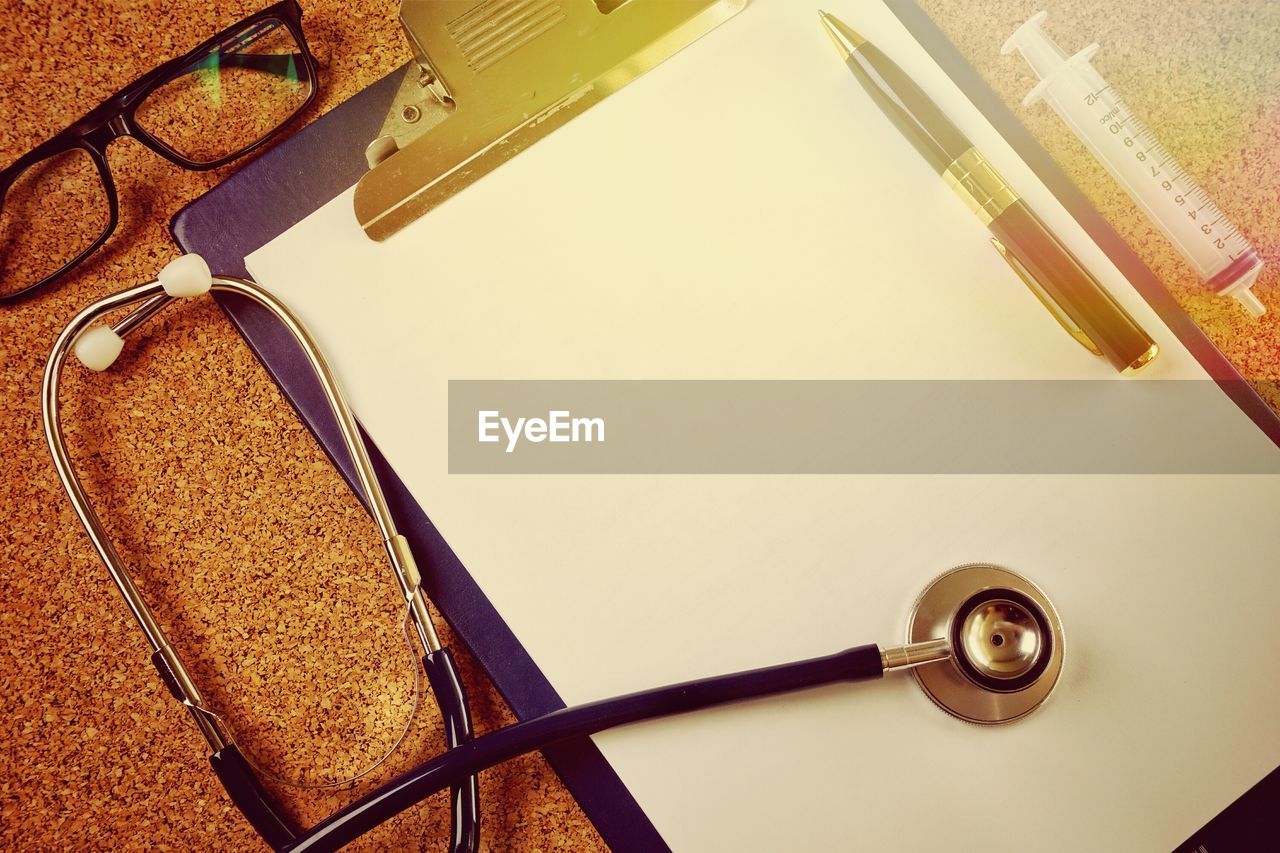 High angle view of medical equipment with clipboard and eyeglasses