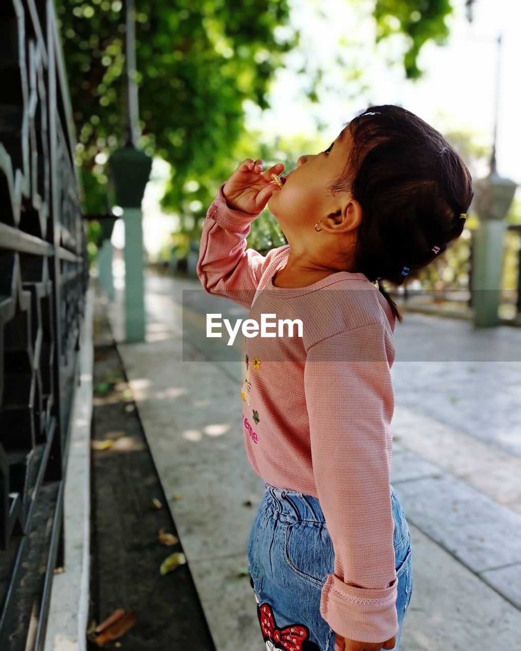 Side view of girl standing on footpath