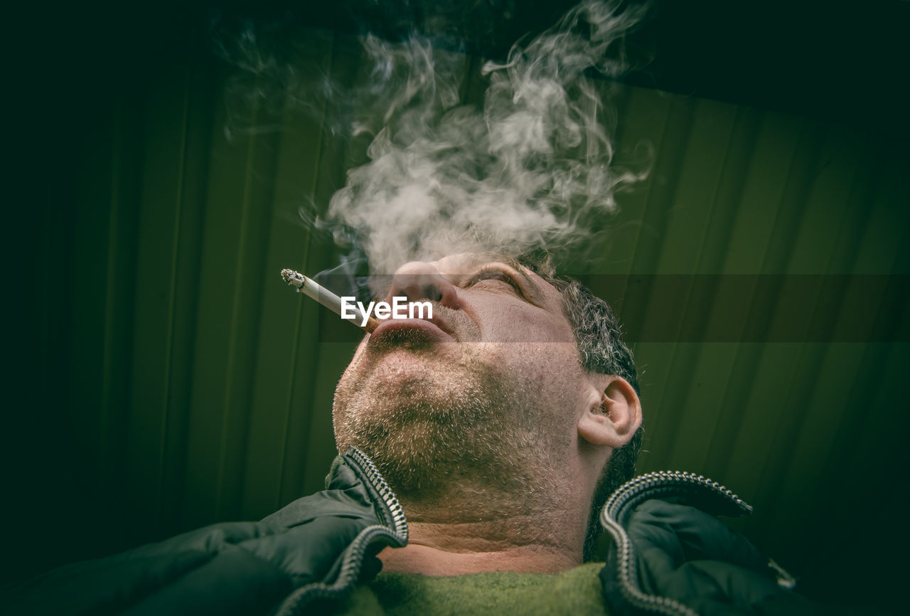 Low angle view of man smoking cigarette