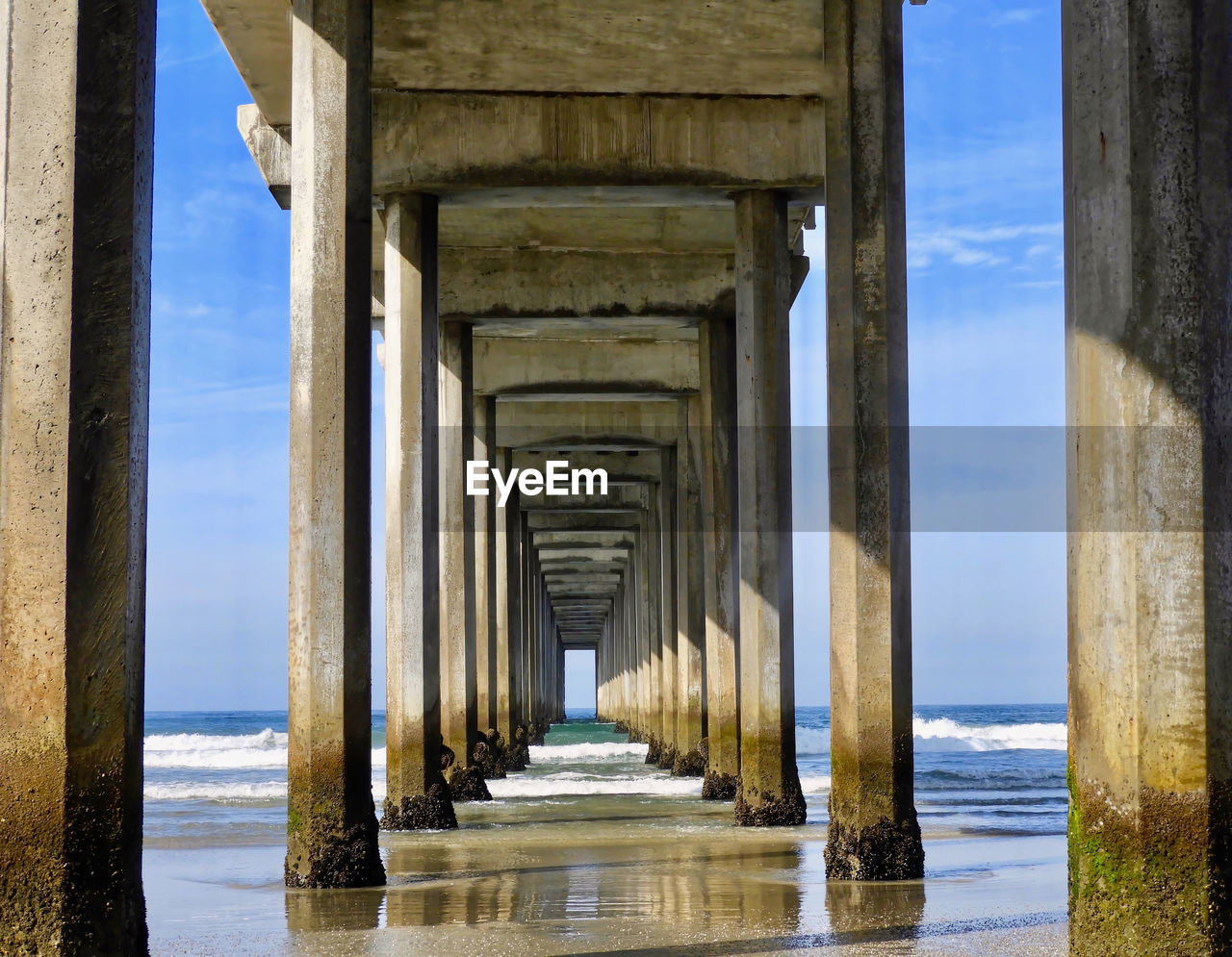 Pier on sea against blue sky