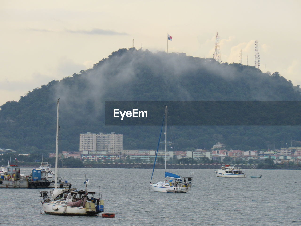 SAILBOATS IN SEA AGAINST MOUNTAIN