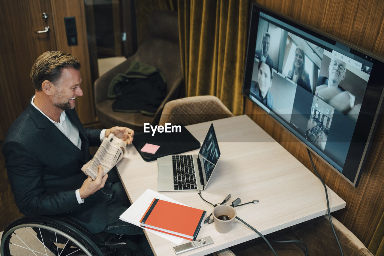 High angle view of disabled businessman with discussion on video call during covid-19