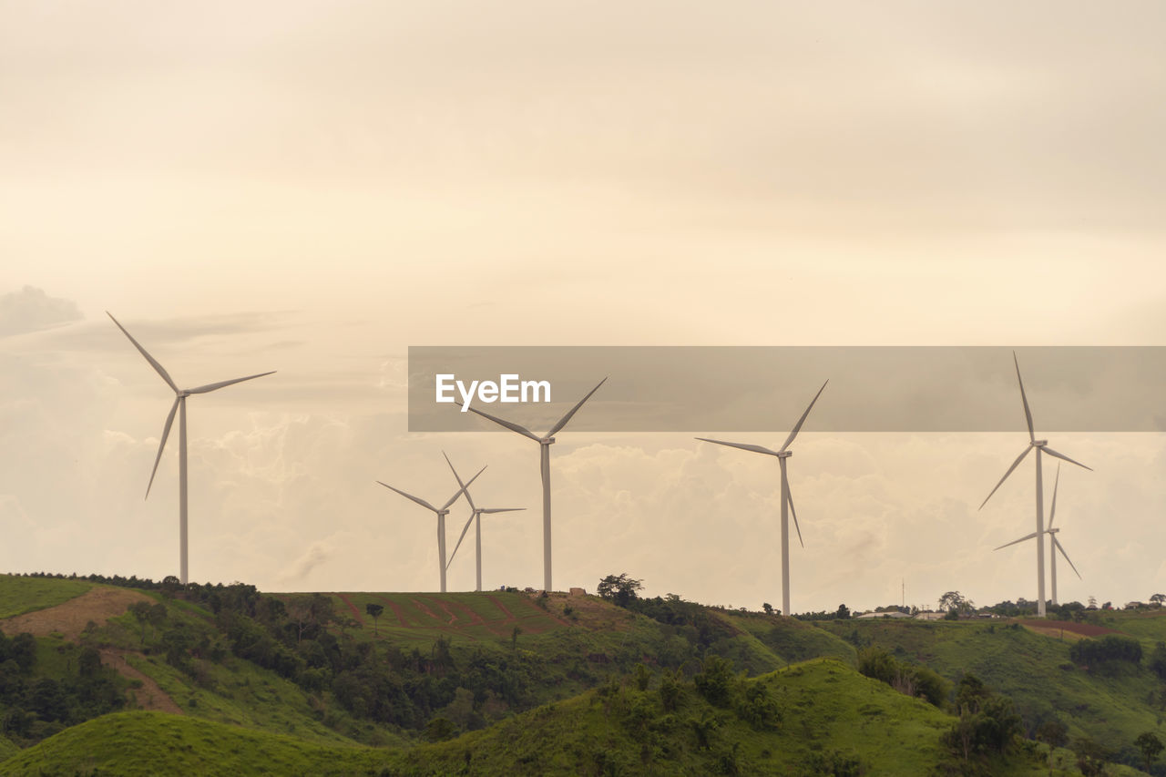 WIND TURBINES ON FIELD AGAINST SKY