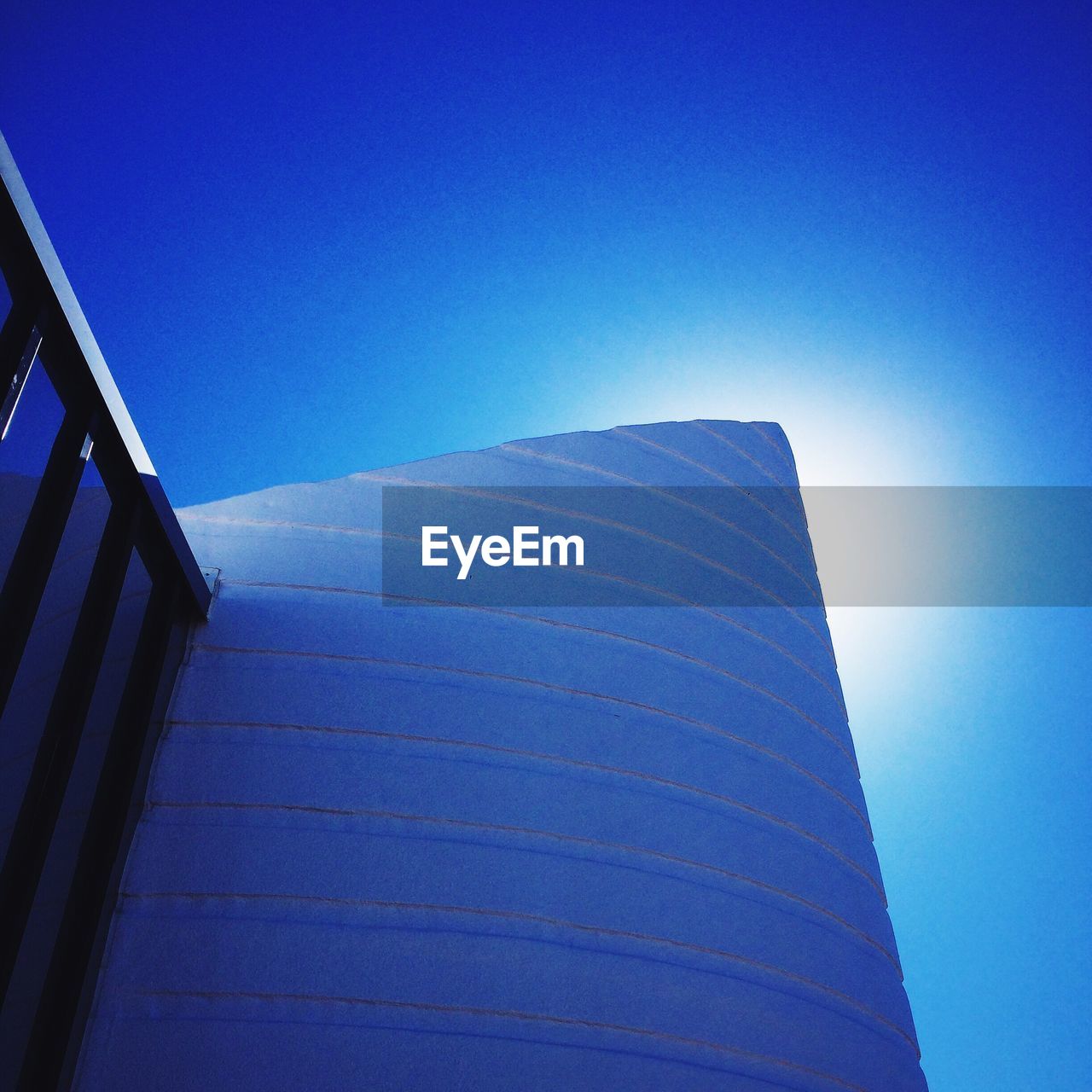 LOW ANGLE VIEW OF TALL BUILDING AGAINST CLEAR BLUE SKY